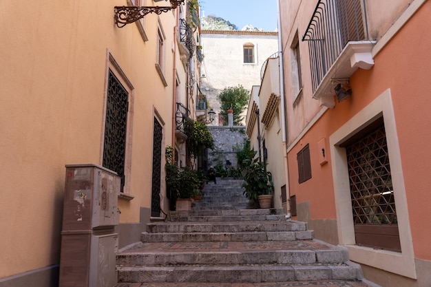 A narrow alleyway with a few potted plants and a bench