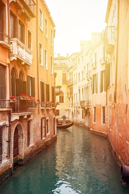 Narrow canal with gondolas in Venice Italy