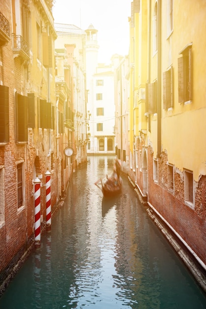 Narrow canal with gondolas in Venice Italy