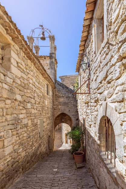 Narrow cobblestone street vernacular architecture bell clock tower of Lacoste Vaucluse France