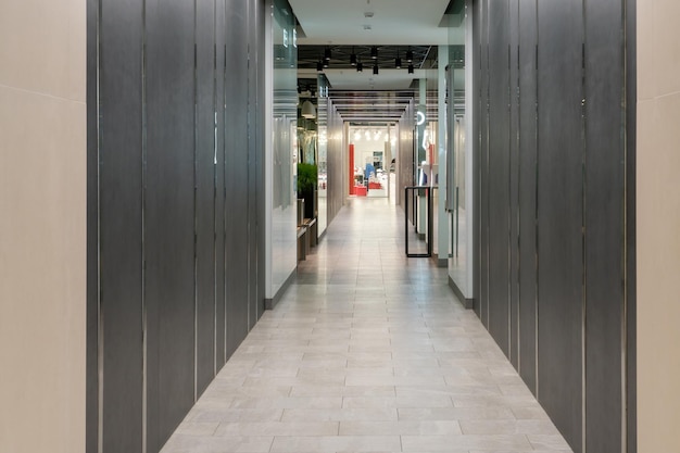 A narrow corridor of the restaurant with lighting and metal walls Mirrored metal surface reflecting light from the diode backlight