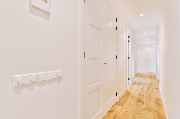 Narrow corridor with doors and lamp