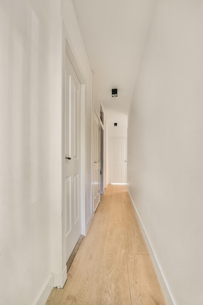 Narrow corridor with doors and lamp