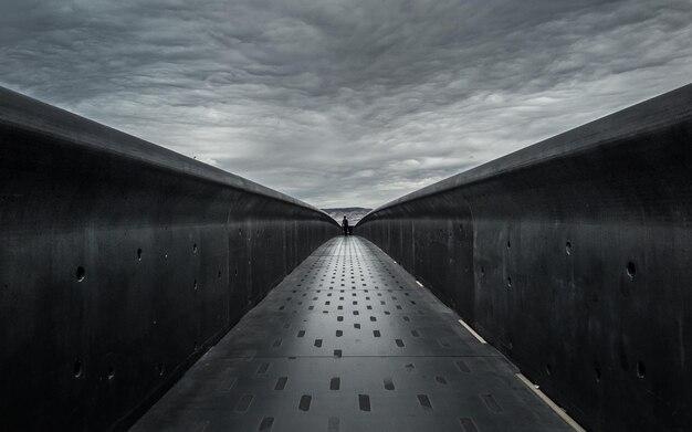 Photo narrow footbridge under cloudy sky