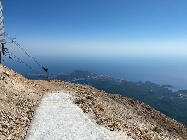 Foto stretta strada di montagna che si snoda in alto sopra il mare