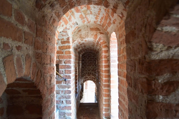 Narrow old ancient castle corridors tunnels arches of red stone bricks in a medieval castle