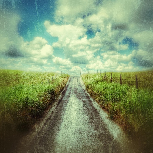 Narrow road along countryside landscape