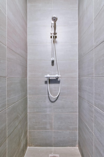 A narrow shower room with dark tiles