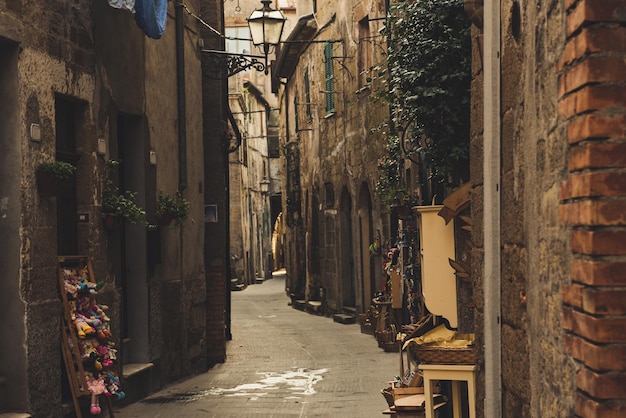 Narrow street of medieval ancient tuff city Pitigliano, travel Italy background