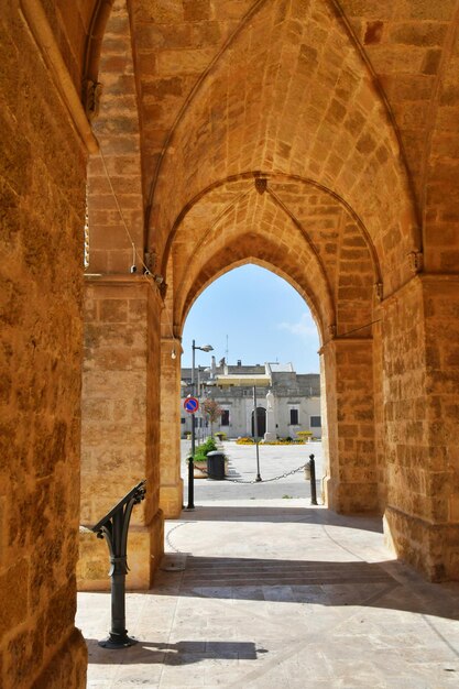 Photo a narrow street between the old houses of uggiano a medieval town in the puglia italy