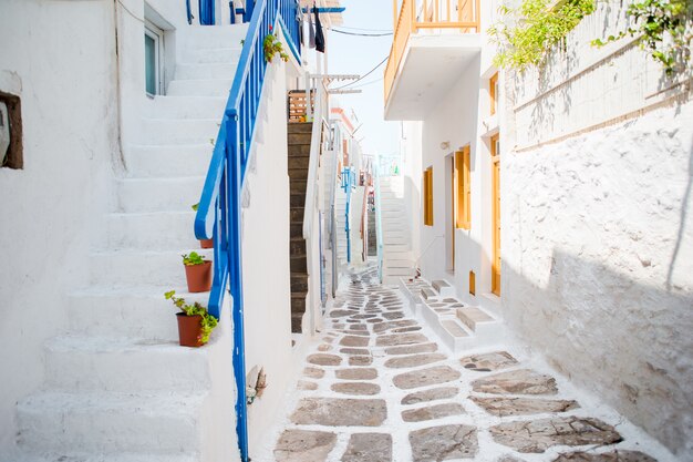 The narrow streets of the island with blue balconies, stairs and flowers.