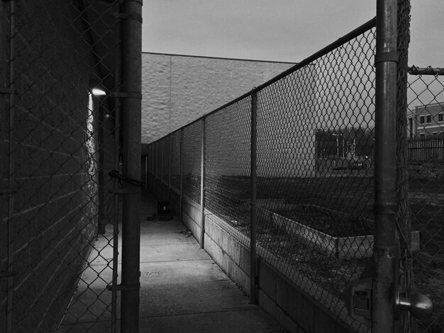 Photo narrow walkway by chainlink fence