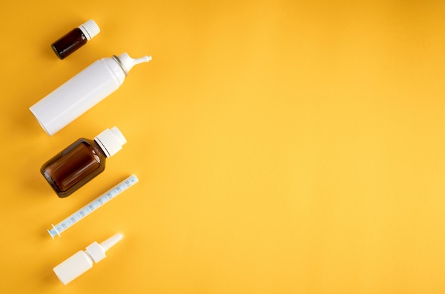Nasal spray bottle composition, white blank bottle on yellow background with copyspace