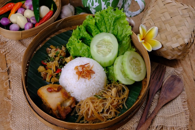 Nasi Berkat Pekalongan. is rijst met bijgerechten van gebakken kip, gewokte pittige groenten.