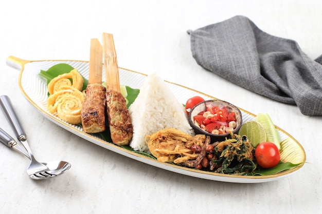 Nasi Campur Bali. Balinese Dish of Steamed Cone Shaped Rice with Variety of Side Dishes, such as Sate Lilit, Ayam Pelalah, Telur Dadar, Kacang Teri, Sambal Matah, Jukut Urap.