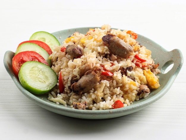 Nasi Goreng Cumi Asin (오징어 볶음밥), 고추로 요리, 매운 맛. 전형적인 인도네시아 수제 음식. 흰색 배경에 고립 된 녹색 접시에 제공