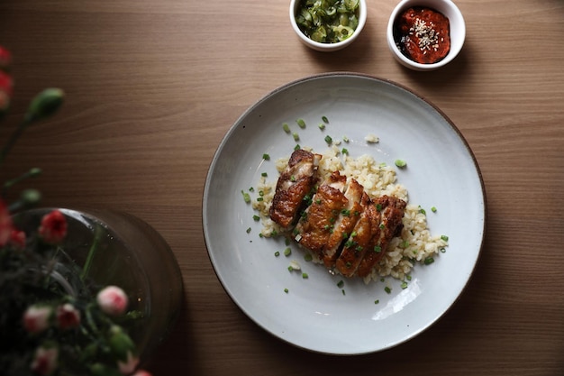 Riso fritto di nasi goreng con pollo su fondo di legno nella vista superiore