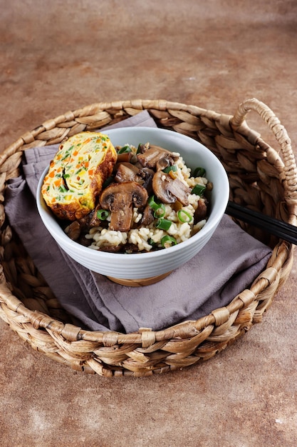 Nasi jamur Rijstchampignon of risotto met rijst en champignons geserveerd met opgerolde omelet