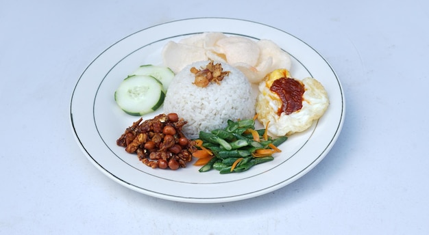 Nasi lemak met een bijgerecht van gebakken eieren en groenten en gebakken pinda's