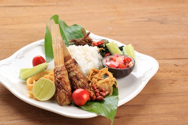 Nasi Lemak 또는 Nasi Campur Bali Sate Lilit Ayam Sisit Sambal Matah와 땅콩을 곁들인 인도네시아 발리 쌀