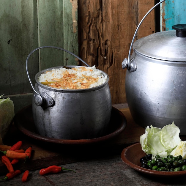 写真 nasi liwet、インドネシア西ジャワの伝統料理。伝統的なインドネシアのスパイスを使用して調理された米から作られ、通常は野菜、サンバル、その他のおかずと一緒に出されます。 kastrolで提供