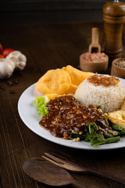 Nasi pecel - индонезийская еда, приготовленная из смеси зеленых листовых овощей с арахисовым соусом и жареным яйцом