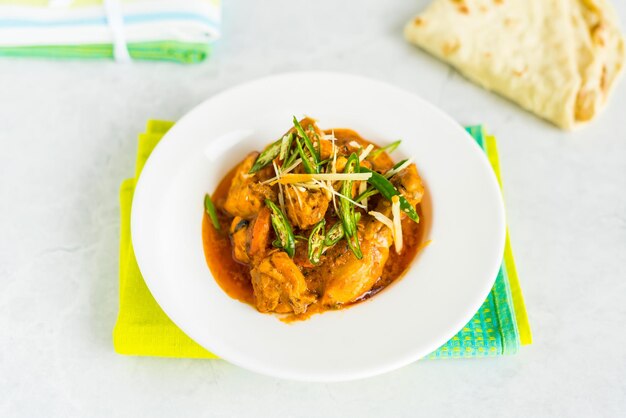 Photo nasty chicken korma karahi masala topping with ginger and green pepper served in dish isolated on table top view of arabic food