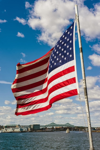 National American flag and building of Boston in the United States. The current version of the flag with 13 horizontal stripes and 50 small stars was adopted on July 4, 1960.