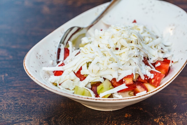 レストランのテーブルの上の白いプレートにバルカン料理の野菜サラダ。