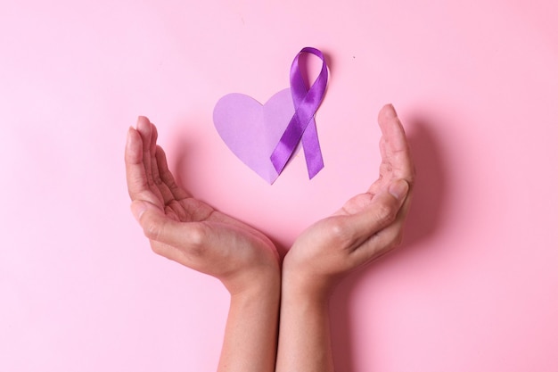 National Epilepsy or Alzheimer disease Day Concept Hands with purple ribbon symbol and purple heart