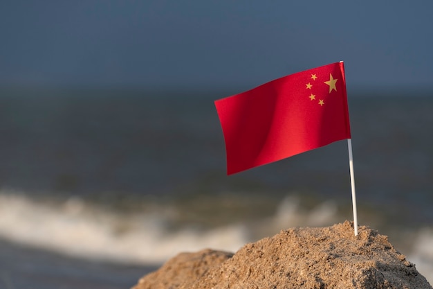 National flag of China on sea surface. Vacation in People's Republic of China on the beach.