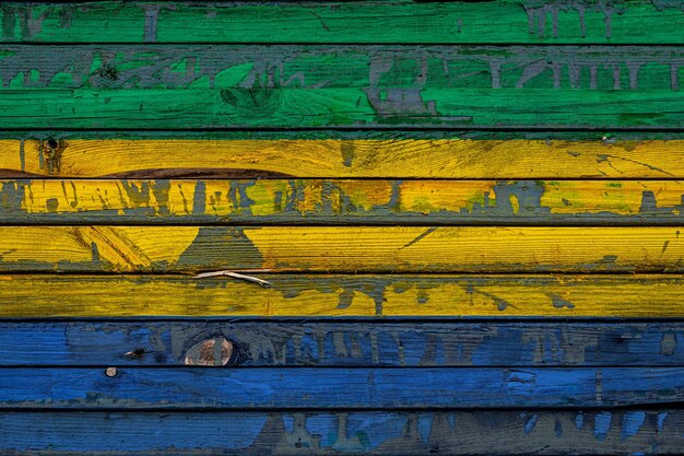 The national flag of Gabon is painted on uneven boards Country symbol
