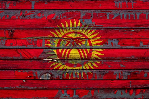 Photo the national flag of kyrgyzstanxa is painted on uneven boards country symbol