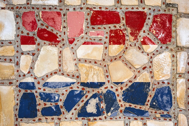 Государственный флаг Нидерландов на фоне каменной стены Флаг баннер на фоне каменной текстуры