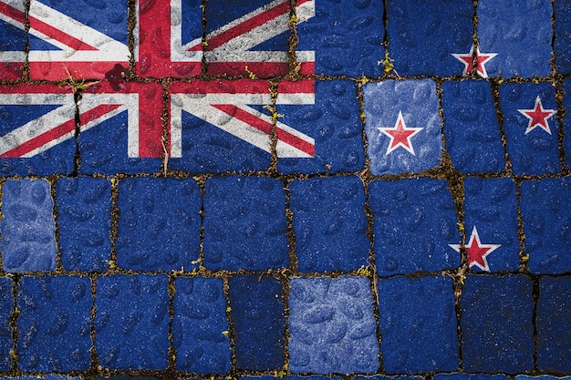 石の壁の背景にニュージーランドの国旗。石のテクスチャの背景に旗バナー。