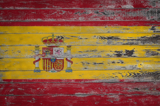 Photo the national flag of spain is painted on uneven wooden boards country symbol