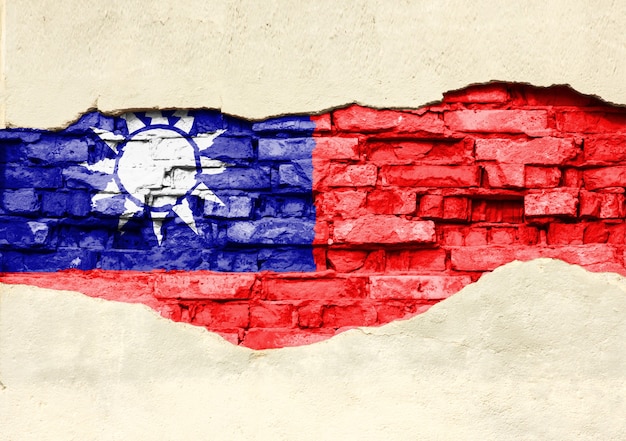 Национальный флаг Тайваня на фоне кирпича. Кирпичная стена с частично разрушенной штукатуркой, фоном или текстурой.