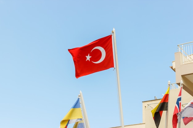 The national flag of Turkey blowing in the wind against a blue sky