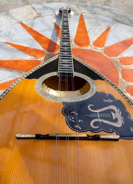 The national Greek stringed plucked musical instrument Bouzouki lies on a marble table in Greece