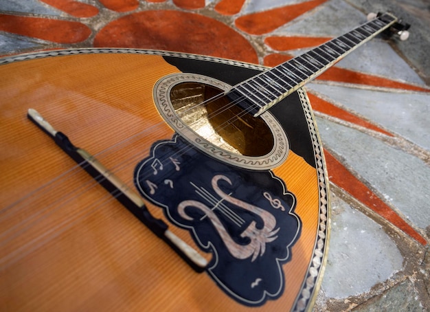 The national Greek stringed plucked musical instrument Bouzouki lies on a marble table in Greece