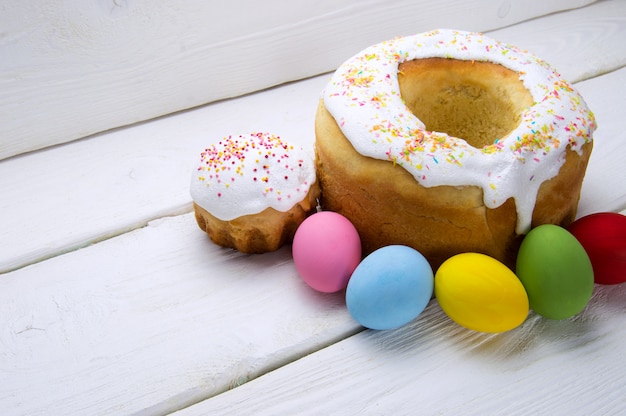 National Russian holiday Easter cake and colored eggs on white wooden surface