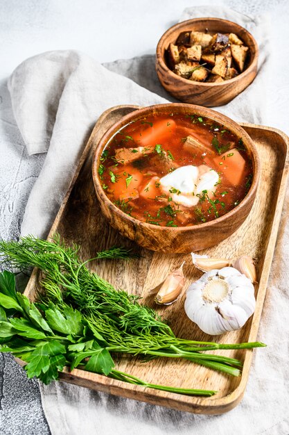 National Russian and Ukrainian Borsch beetroot soup in a wooden bowl. Gray background. Top view