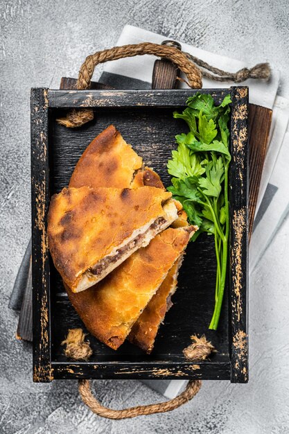 National traditional Caucasian cuisine Ossetian pie with beef meat White background Top view