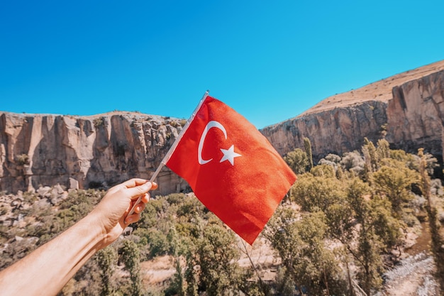 The national Turkish flag with famous Ihlara valley in Cappadocia in the background Travel and tourism