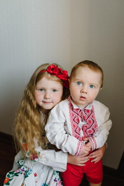 Foto nationale etnische traditionele klederdracht of jurk portret van een kind gekleed in oekraïense folkloristische geborduurde kleding een kindmeisje met een krans van klaprozen op zijn hoofd oekraïense douanetradities