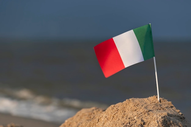 Nationale vlag van Italië op zee achtergrond Vakantie in Italië aan het strand