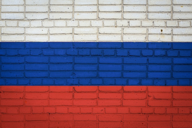 Nationale vlag van Rusland in verfkleuren op een oude bakstenen muur. Vlag op bakstenen muurachtergrond.