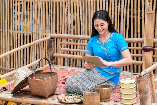 Native woman in the northeast of Thailand in blue dress and technology