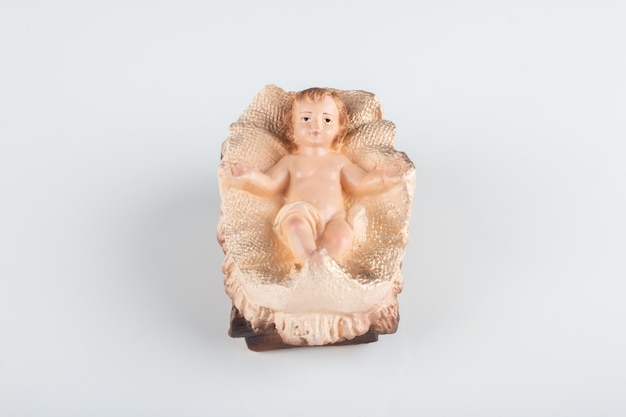 Nativity scene figurine of baby jesus with white background.