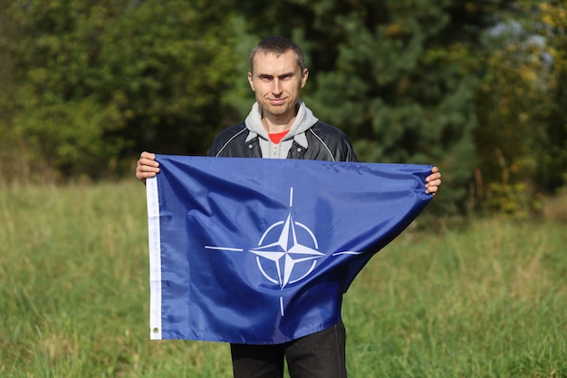 NATO flag in the hands of a man